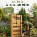 Douche de jardin en bois construite dans un jardin verdoyant, parfaite pour les journées d'été.
