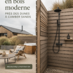 Maison en bois moderne près des dunes, avec grandes fenêtres et façade chaleureuse.