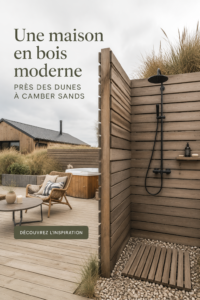 Maison en bois moderne près des dunes, avec grandes fenêtres et façade chaleureuse.